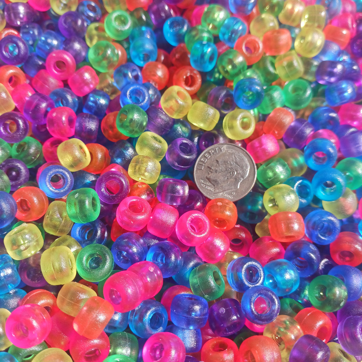 
                  
                    Colorful plastic pony beads with a dime for size comparison.
                  
                