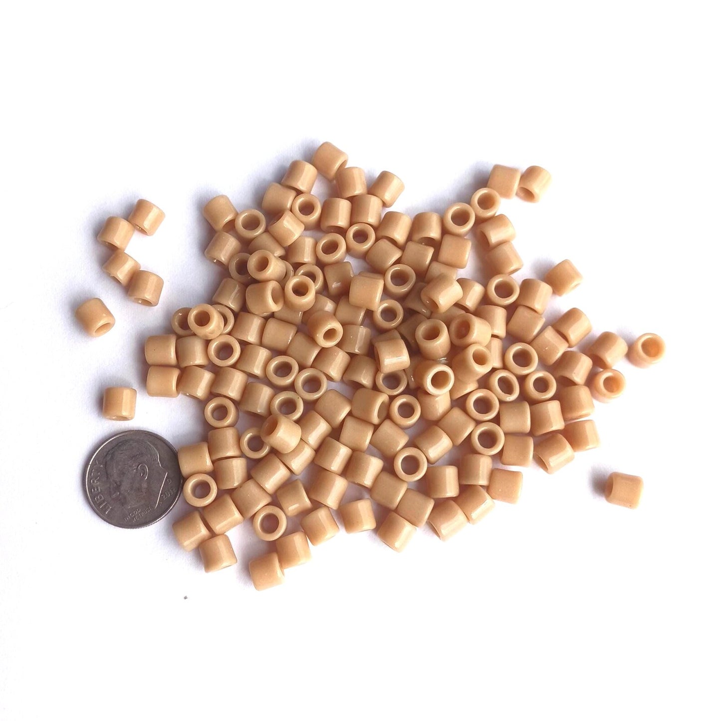 
                  
                    Tan tile beads next to dime for size

                  
                